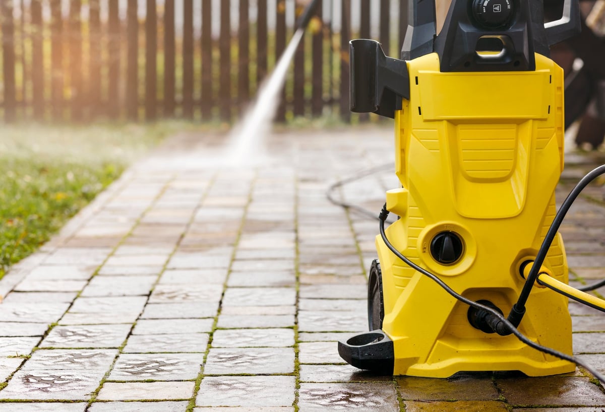High pressure cleaning restoring an exposed aggregate paved surface